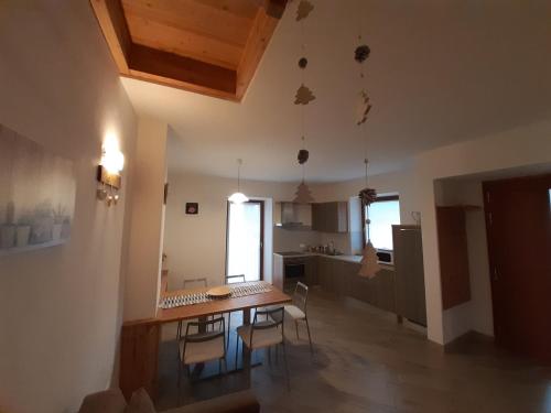una cucina e una sala da pranzo con tavolo e sedie di Appartamento Morettina con terrazzo a Levico Terme