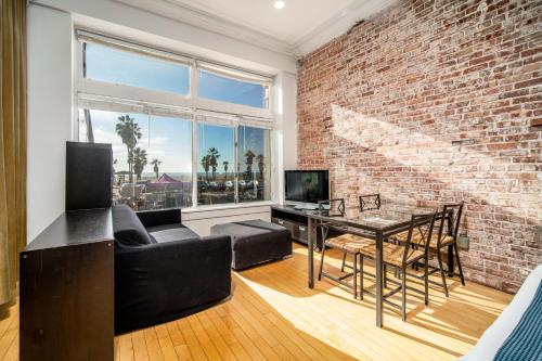 a living room with a brick wall and a table at AIR Venice on the Beach in Los Angeles