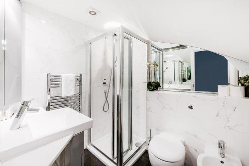 y baño blanco con ducha y aseo. en Lovely 2 bedroom apartment in Notting Hill, en Londres