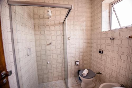a bathroom with a shower with a toilet and a window at HAVANA ECONOMY in Uberaba