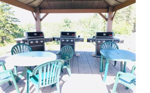 a patio with tables and chairs and two barbecueurgers at Mountain View Resort and Suites at Fairmont Hot Springs in Fairmont Hot Springs