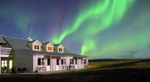 a house with the northern lights in the sky at Hótel Lækur in Hella