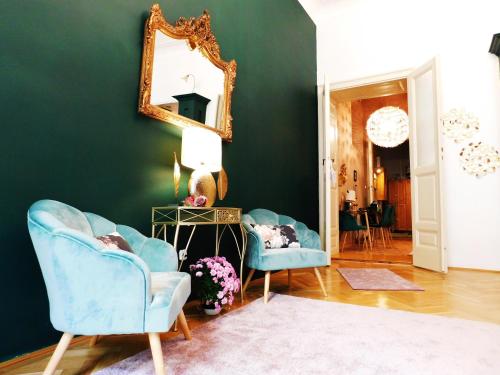 a living room with two blue chairs and a mirror at Wonder Deer Lux Apartment at the Parliament self check-in in Budapest