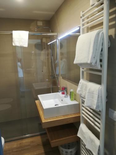 a bathroom with a sink and a mirror and towels at Locanda San Marco in Torri del Benaco