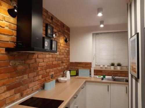 una cucina con muro di mattoni e piano di lavoro di PuckApartments a Puck