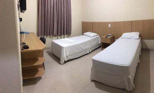 a hospital room with two beds and a desk at Hotel Rotamerica in Campinorte