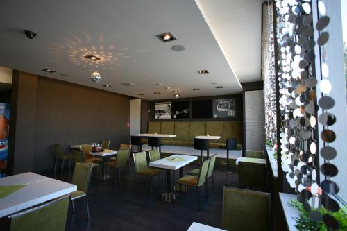 a restaurant with tables and chairs in a room at Hotel EMPIRE in Trnava