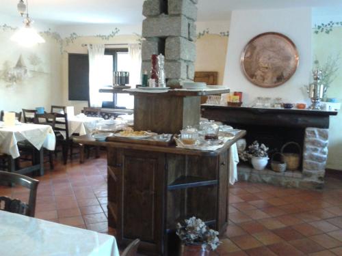 a restaurant with a fireplace in the middle of a room at Agriturismo Il Muto di Gallura in Aggius