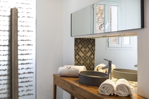 La salle de bains est pourvue de 2 lavabos et d'un comptoir avec des serviettes. dans l'établissement Suite Azur Hotel, à Essaouira