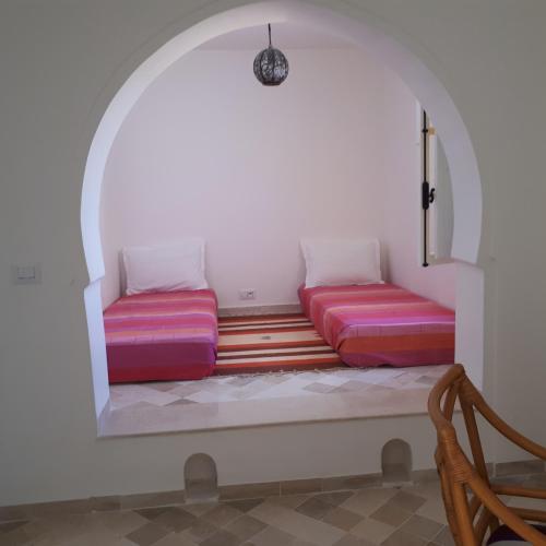 a room with two futon beds in an archway at Dar El Jerbi in Mezraya