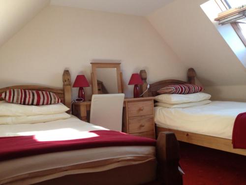 a attic bedroom with two beds and a mirror at Bed and Breakfast at 4 in Thurso