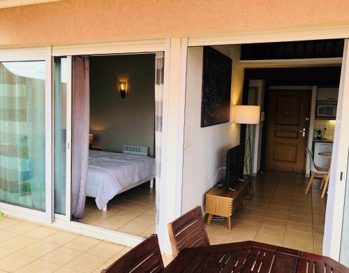 - une vue sur une chambre depuis un balcon avec un lit dans l'établissement les reflets, à Saint Cyprien Plage