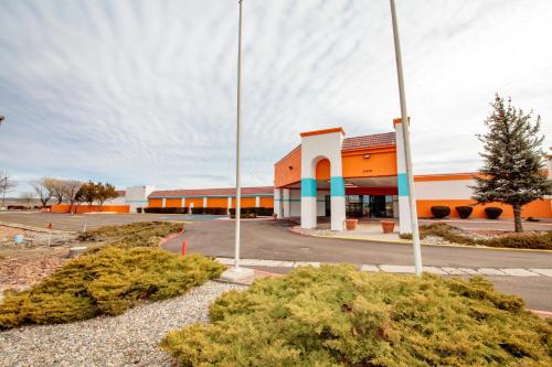 an orange building with two poles in a parking lot at Howard Johnson by Wyndham Gallup in Gallup