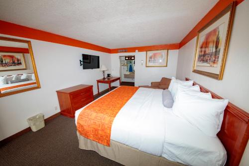 een hotelkamer met een groot bed en een televisie bij Howard Johnson by Wyndham Gallup in Gallup