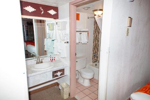 ein Badezimmer mit einem Waschbecken, einem WC und einer Badewanne in der Unterkunft Howard Johnson by Wyndham Gallup in Gallup