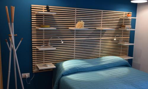 a bedroom with a bed and a blue wall at INCANTO A CHIAIA in Naples