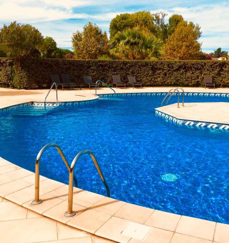 - une piscine d'eau bleue dans un complexe dans l'établissement les reflets, à Saint Cyprien Plage