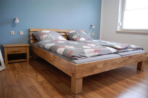 een houten bed met kussens in een kamer bij Harz Haus Kati - Fewo Talblick in Bad Sachsa