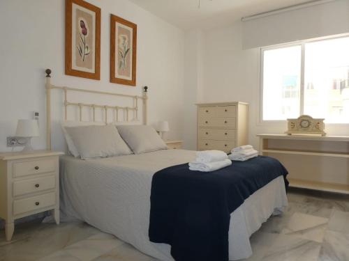 a bedroom with a bed with towels on it at MALDONADO LUJO SUPERIOr CENTRO MALAGA in Málaga