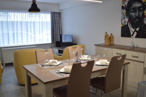 a dining room with a table and yellow chairs at Residentie Mercator All in Formule in Ostend