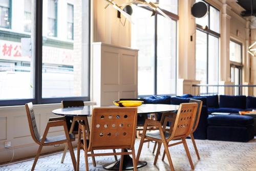 a dining room with a table and chairs and a couch at Walker Hotel Tribeca in New York