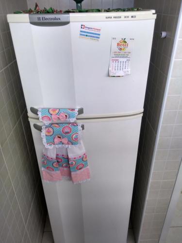 a white refrigerator with towels on it in a kitchen at Apto Praia da Enseada 4 pessoas in Guarujá