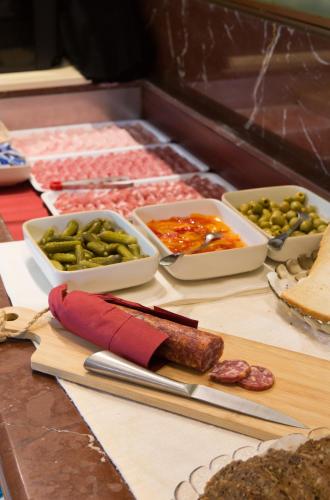 a table topped with bowls of pickles and other food at Hotel Campagnola in Bardolino