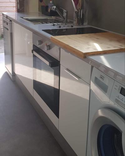 une cuisine avec une cuisinière et une machine à laver dans l'établissement Carré Saint-Gervais Rouen centre, à Rouen