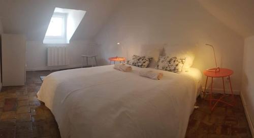 a bedroom with a white bed with two tables and a window at Carré Saint-Gervais Rouen centre in Rouen