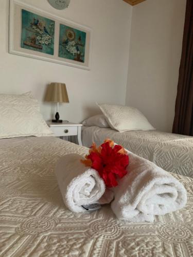 a hotel room with towels and a flower on a bed at Teanehi Bed & Breakfast in Hanga Roa