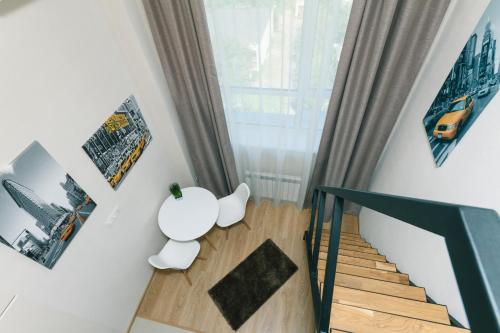 a room with a staircase and a white table and chair at My SmartApart Hotel Today in Kyiv