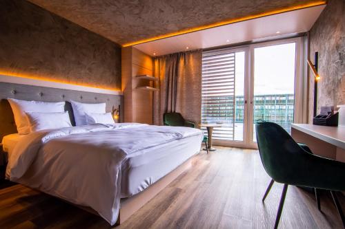 a bedroom with a large bed and a large window at Meiser Design Hotel in Dinkelsbühl