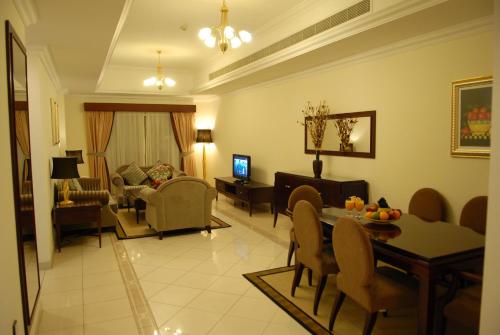 een woonkamer met een eettafel en een woonkamer bij Al Manar Hotel Apartments in Dubai