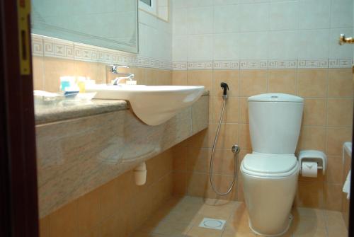 a bathroom with a toilet and a sink at Al Manar Hotel Apartments in Dubai
