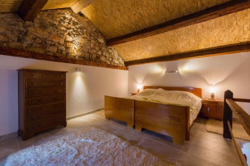 a bedroom with a bed and a wooden dresser and a drawer at Villa Casa Royal in Bribir