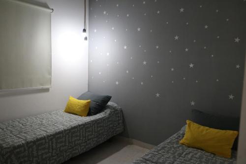 un dormitorio con 2 camas y una pared con estrellas. en Almar VI en 