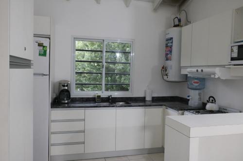 una cocina con armarios blancos y una ventana en Almar VI en 