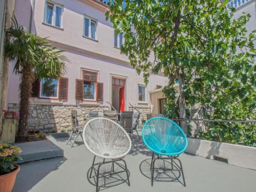 two chairs sitting in front of a building at House Haus Marijo in Crikvenica