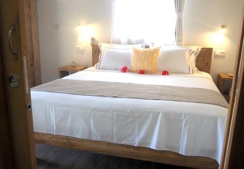 a bedroom with a large bed with white sheets and pillows at Fare noanoa in Mariuti