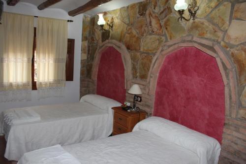 A bed or beds in a room at Casa Rural Laura