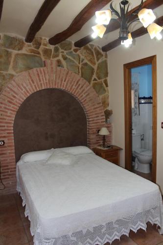 a bedroom with a large bed and a stone wall at Casa Rural Laura in Villafeliche