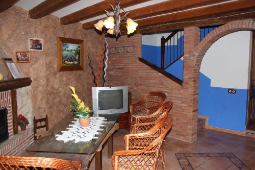 a living room with a table and chairs and a television at Casa Rural Laura in Villafeliche