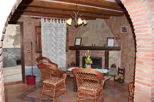 a dining room with a table and wicker chairs at Casa Rural Laura in Villafeliche