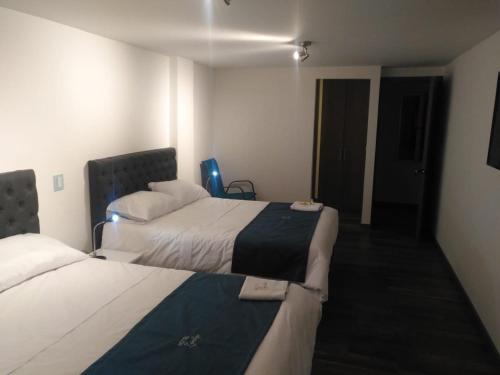 a hotel room with two beds and a hallway at HOTEL ZARCILLEJO in Pasto