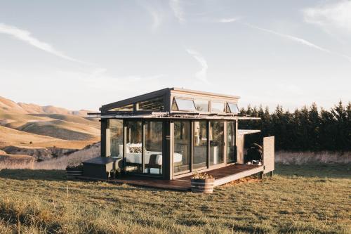 a glass house in a field in a field at Greystone PurePod in Waipara