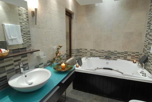 a bathroom with a tub and a sink and a bath tub at Mythos in Elatochori