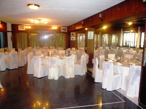 a banquet hall with white tables and white chairs at Hotel Chbat in Bcharré