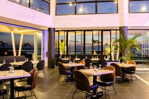 ラゴイにあるDoulos Phos The Ship Hotelのテーブルと椅子、窓のあるレストラン