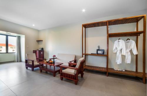 Zimmer mit einem Tisch und Stühlen sowie einem Ankleidezimmer in der Unterkunft Bayon Modern Residence in Siem Reap