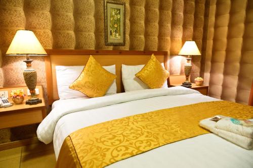 a bedroom with a large bed with two lamps at Mansour Plaza Hotel Apartments in Dammam